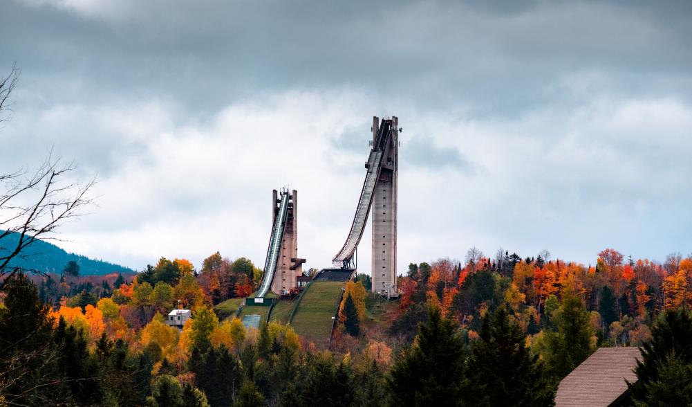 Olympic ski jumps in the distance with fall scenery.