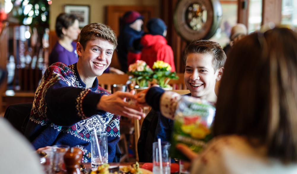 A family in sweaters cheerses their drinks.