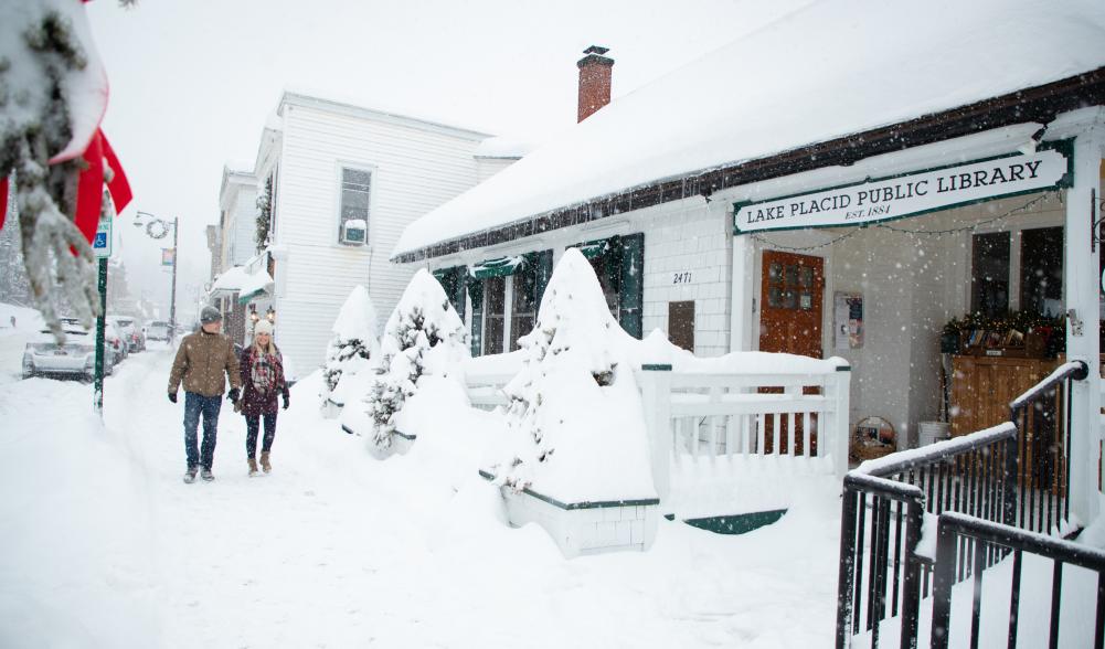 Couple walks down snowy Main Street