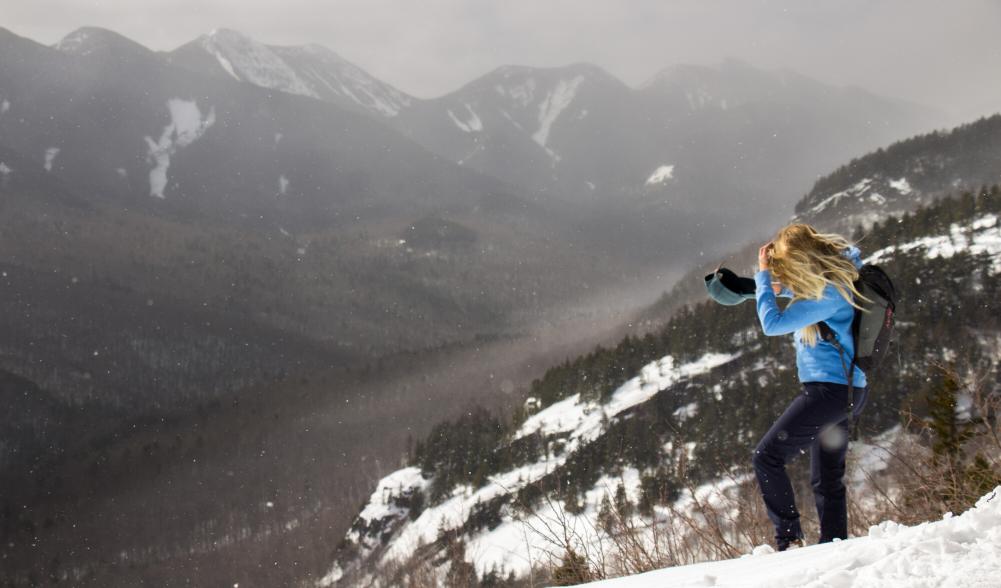 A winter hiker on a cliff of the Three Brothers