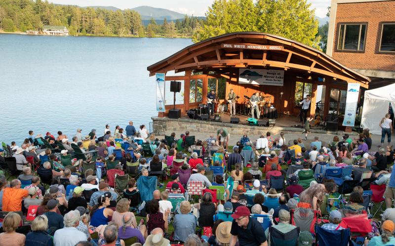 Crowd gathers in Mid's Park on a summer evening to listen to live music.