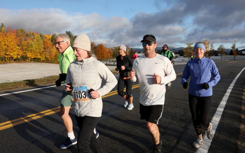 Group of runners on road with frosty fall foliage backdrop