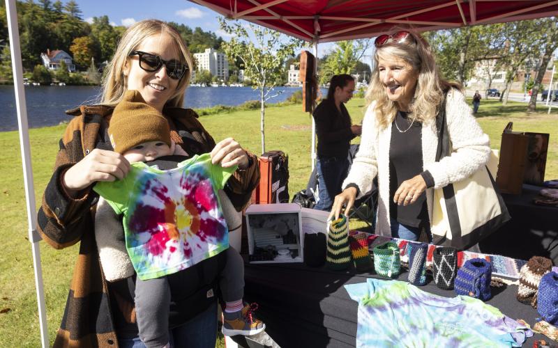 Mom and baby check out a shirt at the ArtMarket in Saranac Lake