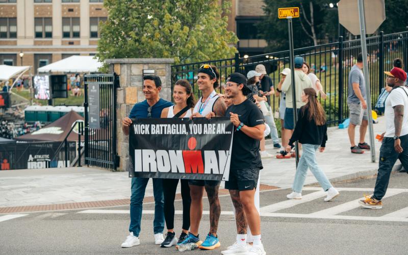 Family stands with Ironman athlete and sign