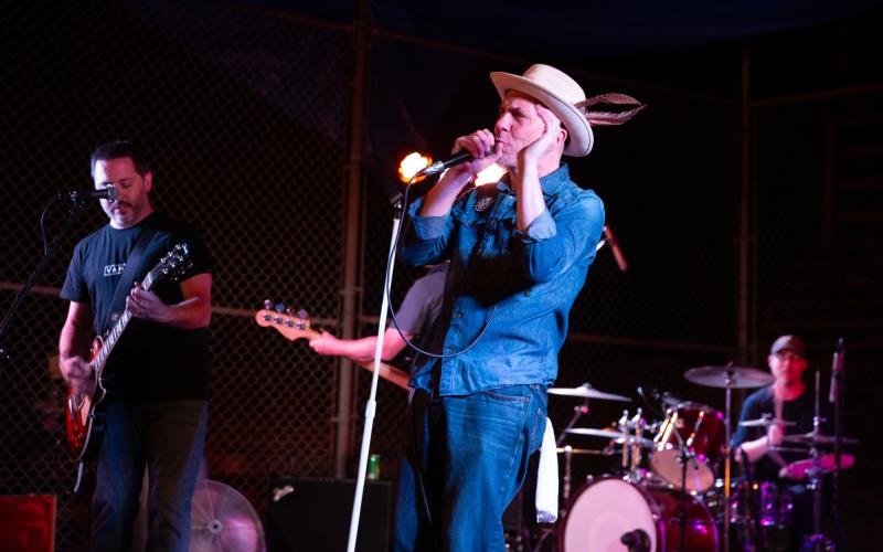 Band playing on stage with guitarist, singer and drums