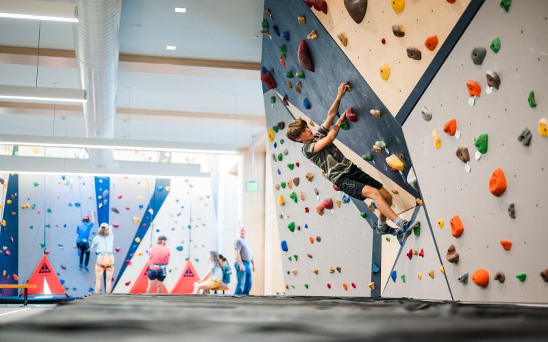 Boy climbing on bouldering wall