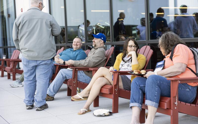 People lounge in Adirondack Chairs on the terrace