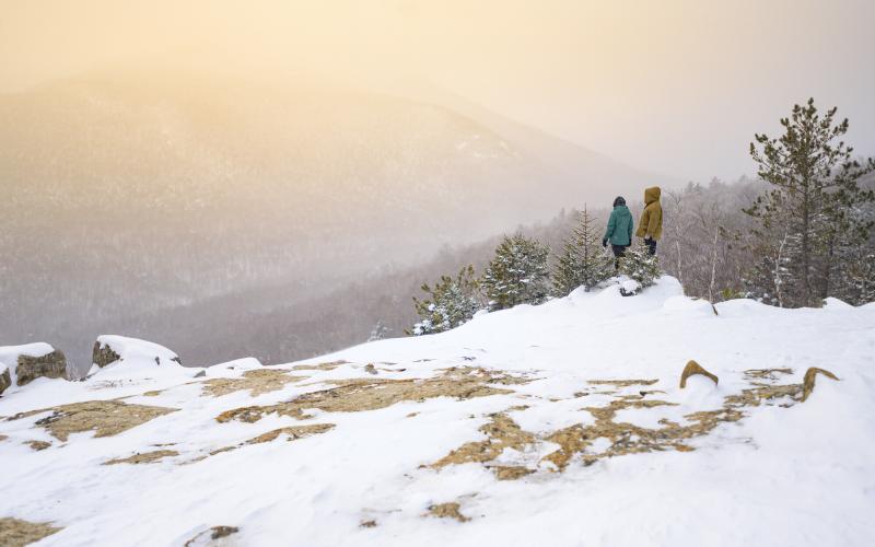 Two people on a snowy open summit