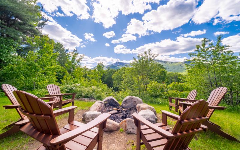 Adirondack chairs around a fire pit with Mountain Views