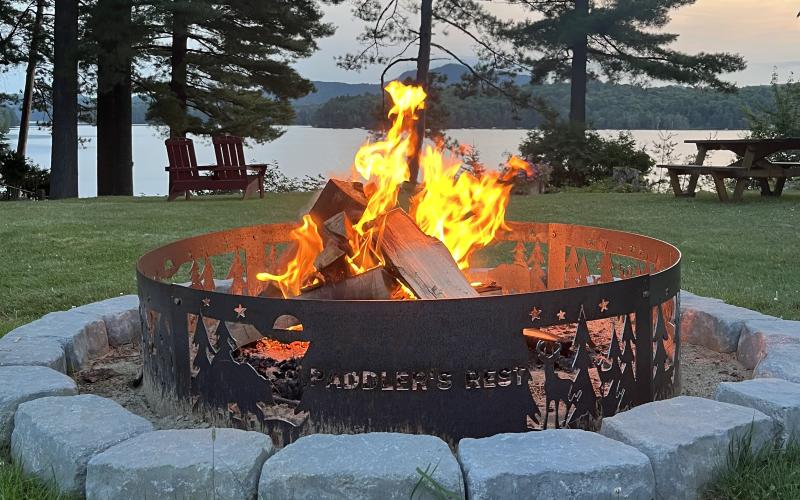 Custom fire ring with a lake view at dusk