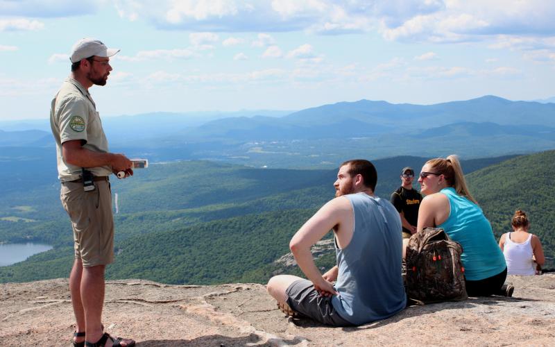 A summit steward educates hikers on the fragile alpine vegetation on Cascade's summit.