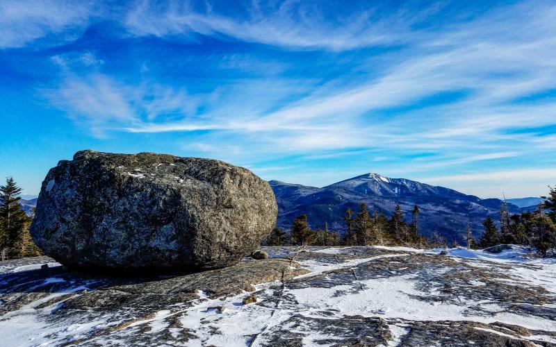 A large boulder on a wintry mountain summit