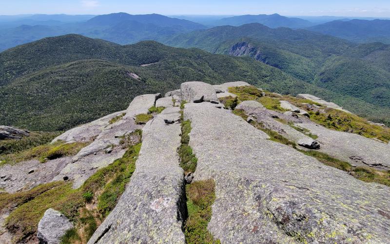 A rocky summit with a view of other tree-covered mountains