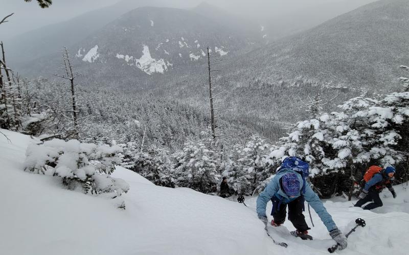 Hikers going up a snow covered cliff