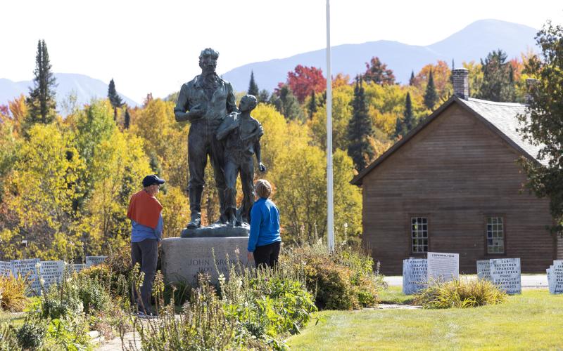 Two people look at a metal statue of John Brown