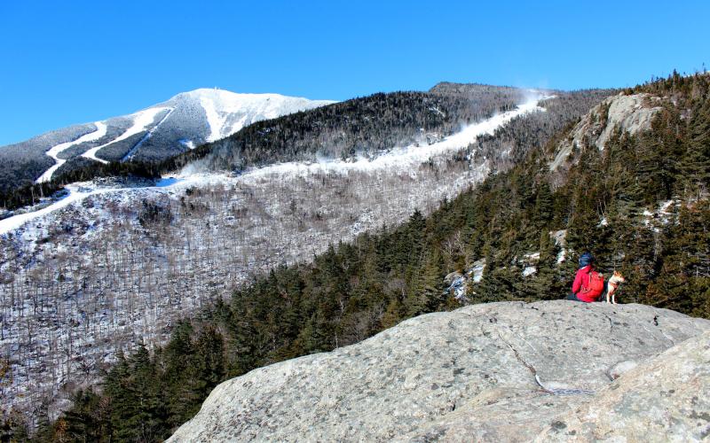 A hiker on a rocky summit in the winter