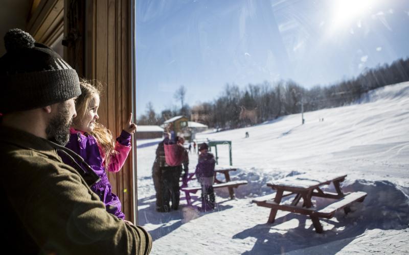 A dad holds his daughter in the lodge at Mt Pisgah