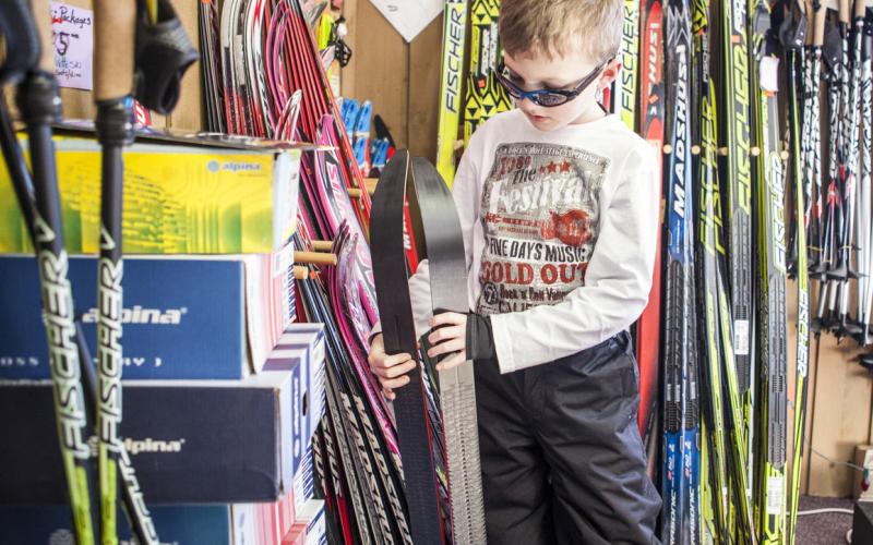 A young kid looks at skis