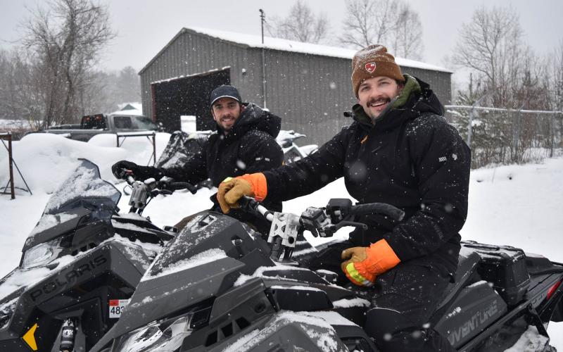 smiling faces atop polaris snowmachines