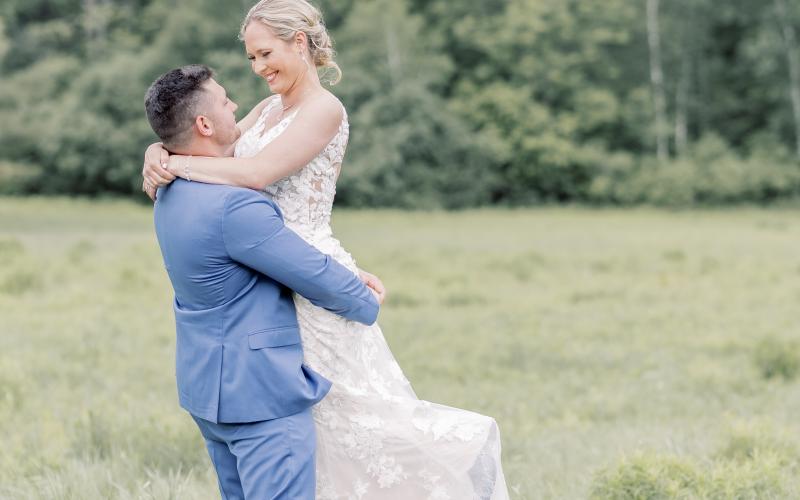 Groom holds bride in the air and spins