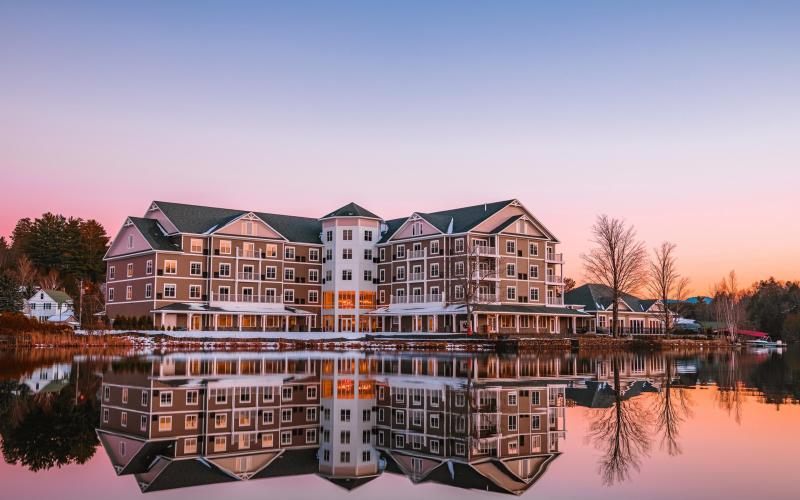 The exterior reflects off Lake Flower in a pink sunset