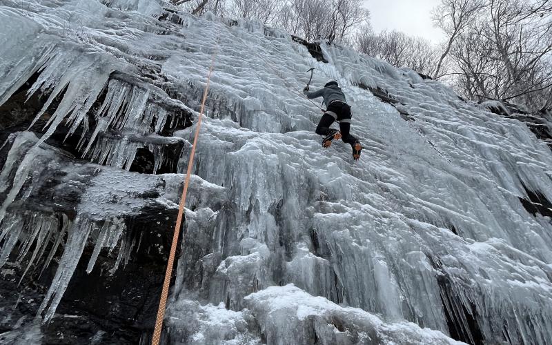 Looking up at a climber scaling an iceflow