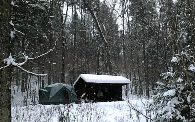 Winter camping set up by a lean to