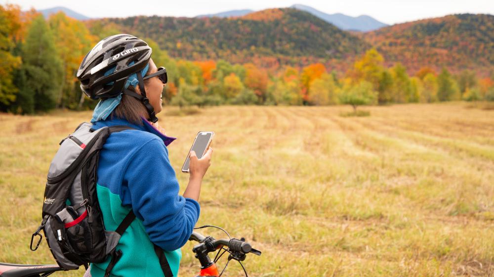 a black woman rides her bike on a fall valley.